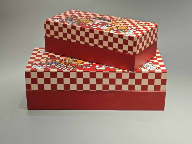 Our product is a custom-designed rectangular gift box in an appealing red color, featuring a checkered lid adorned with playful cartoon characters and food-themed illustrations. This versatile packaging solution is ideal for enhancing any occasion.