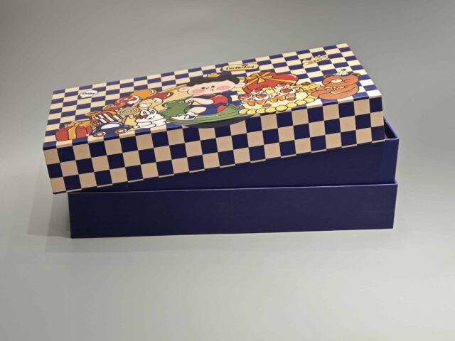 This custom packaging box showcases playful cartoon characters, including a cheerful pig and a chicken, surrounded by a delightful assortment of pastries. The vibrant design is set against an imaginative checkered backdrop, creating an eye-catching presentation for any gift.