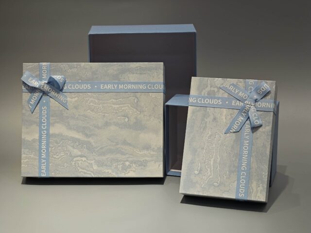 The boxes feature a blue and marbled pattern with a practical lift-off lid and are elegantly finished with blue ribbons.