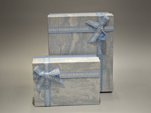 The boxes feature a blue and marbled pattern with a practical lift-off lid and are elegantly finished with blue ribbons.