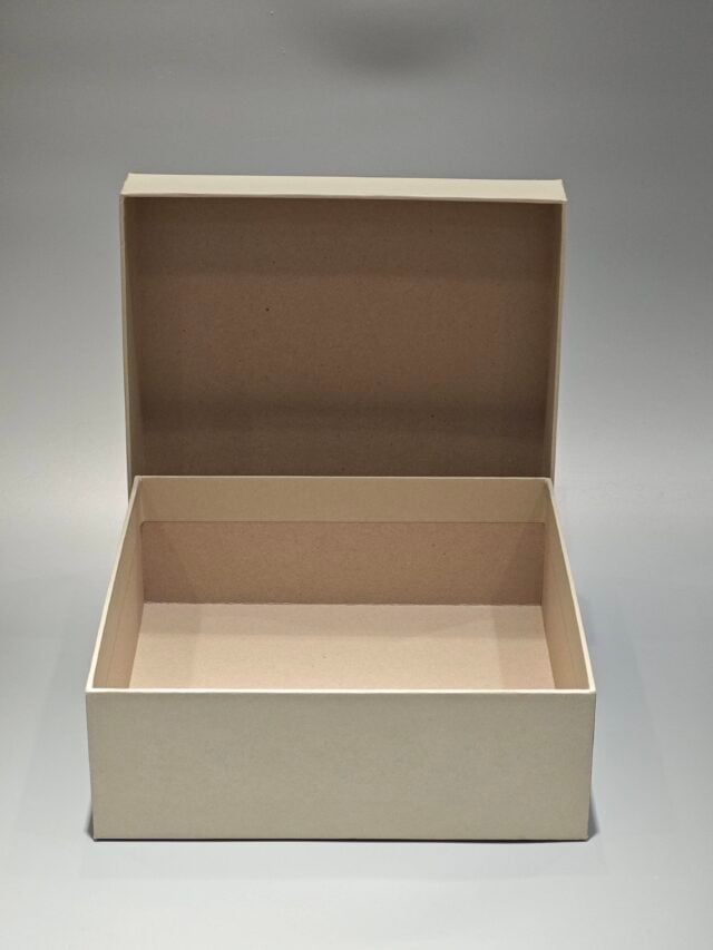 A custom square rigid box with a removable top positioned slightly ajar on the side, set against a neutral backdrop.