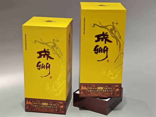 This image showcases our custom wine packaging solution, featuring a vibrant yellow and brown color scheme. The box is adorned with decorative graphics and incorporates a lift-off lid design, suitable for premium wine presentation. Asian-inspired artistic elements enhance the overall aesthetic, while maintaining discretion by not depicting specific text on the packaging.