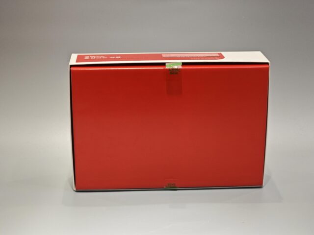 The product is a custom box packaging for a Korean Red Ginseng with Pomegranate product. The box features vibrant and detailed illustrations of ginseng roots and pomegranate fruits, giving it an appealing and eye-catching design. The overall color scheme complements the images, set against a gray surface that enhances the vividness of the artwork. This bespoke packaging highlights both traditional and contemporary aesthetics, reflecting the premium quality of its contents.