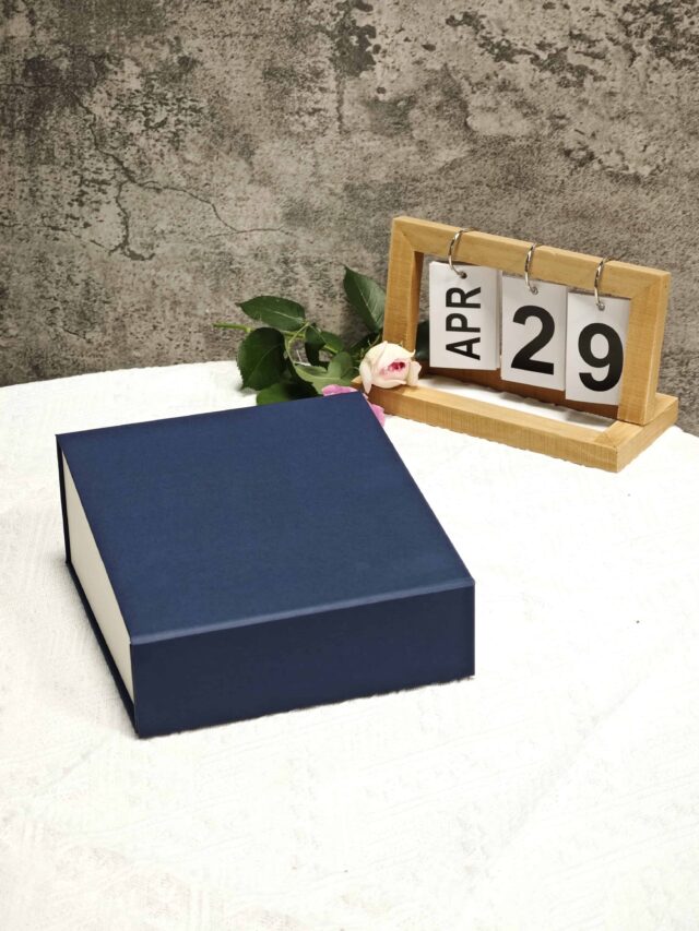 The image showcases an open navy and white collapsible rigid box