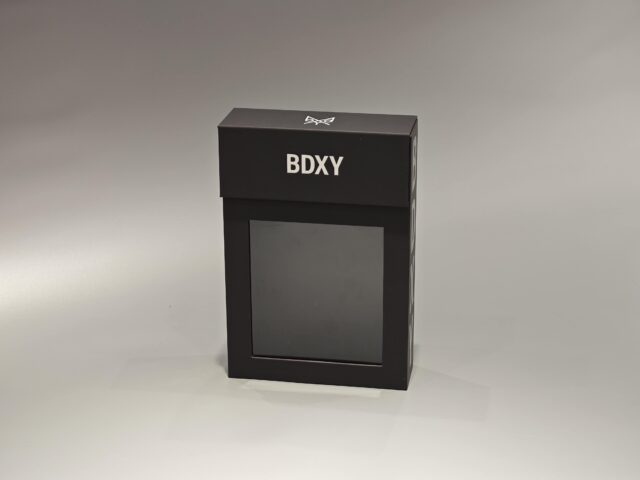 The product is a sleek, black rectangular custom packaging box designed to meet diverse packaging needs. It features a minimalist and sophisticated style, complemented by its neutral background. The box can be customized with logos or brand elements according to client specifications.