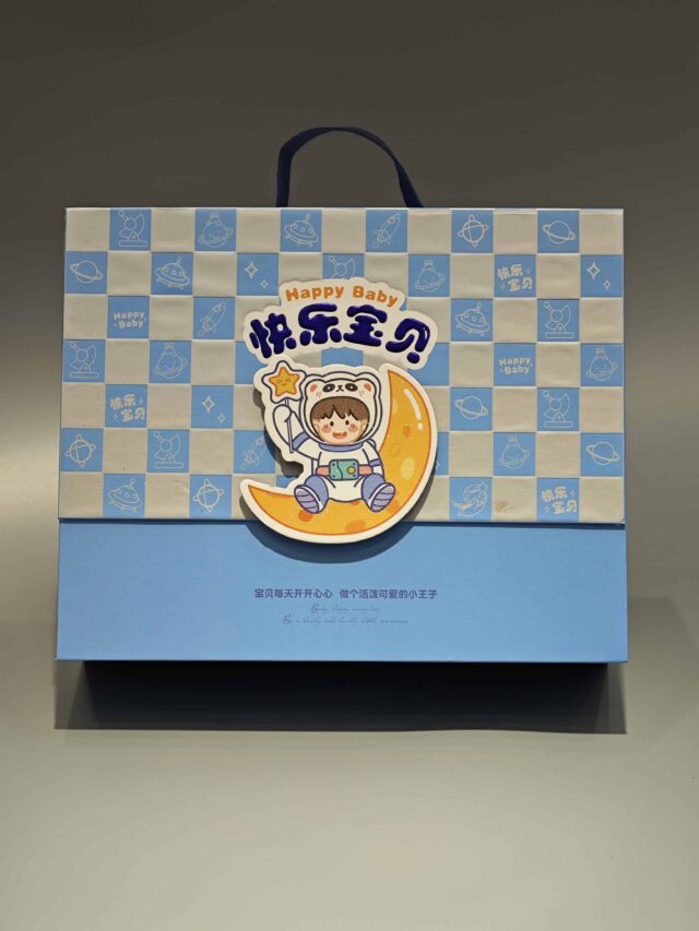 We are a manufacturer of custom box packaging. This product features a design with a child in an astronaut suit sitting on a crescent moon. The box is adorned with checkered blue and white patterns, creating an appealing and whimsical look suitable for celebrating joyful occasions.
